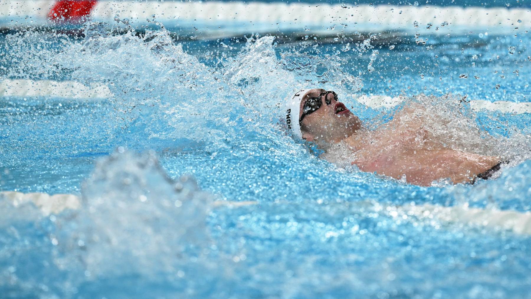 US' Hunter Armstrong competes in a heat of the men's 100m backstroke swimming event during the Paris 2024 Olympic Games at the Paris La Defense Arena in Nanterre, west of Paris, on July 28, 2024.