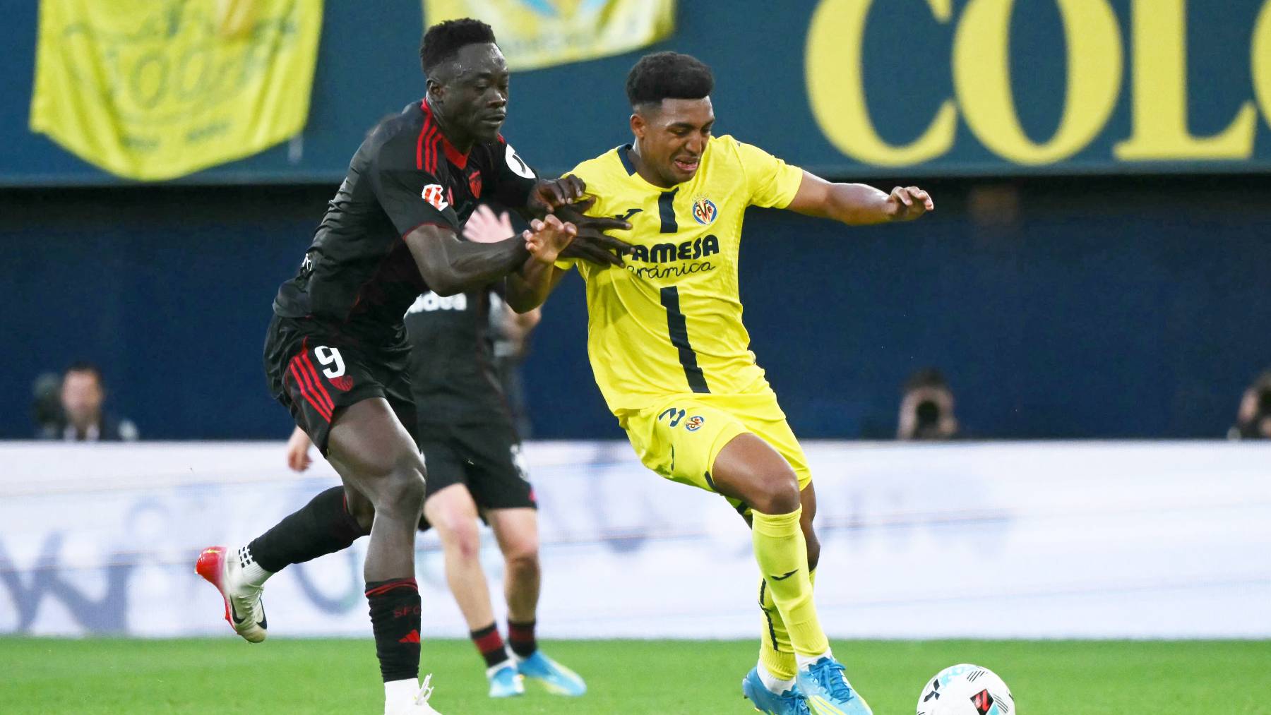 Sevilla's Nigerian forward #09 Akor Jerome Adams challenges Villarreal's US defender #03 Alexander Freeman during the Spanish league football match between Villarreal CF and Sevilla FC at La Ceramica Stadium in Vila-real on May 12, 2026.
