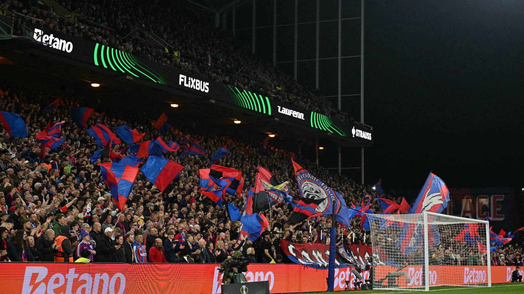 Palace fans fly flags near the end of the UEFA Conference semi-final second-leg football match between Crystal Palace and Shakhtar Donetsk at Selhurst Park in London on May 7, 2026.