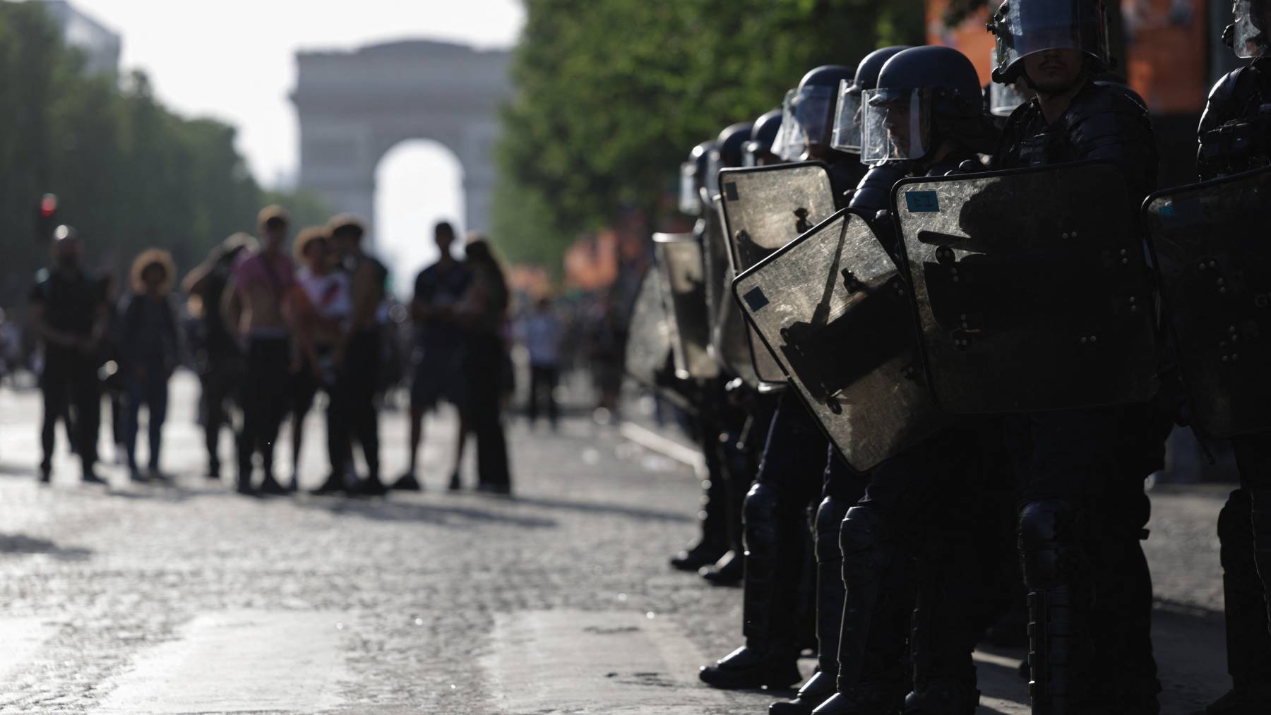 French Republican Security Corps (CRS - Compagnies Republicaines de Securite) Police officers (R) stand by as Paris Saint-Germain's supporters gather on the Champs-Elysees Avenue during the UEFA Champions League final football match between Paris Saint-Germain (PSG) and Arsenal FC played in Budapest, in Paris on May 30, 2026.