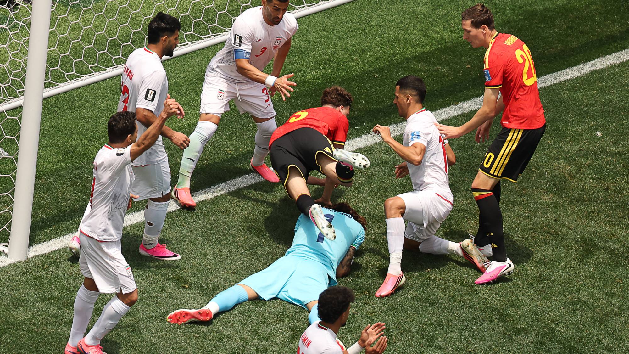 Iran's goalkeeper #01 Alireza Beiranvand makes a save past Belgium's defender #05 Maxim De Cuyper during the 2026 World Cup Group G football match between Belgium and Iran at the Los Angeles Stadium in Inglewood on June 21, 2026.