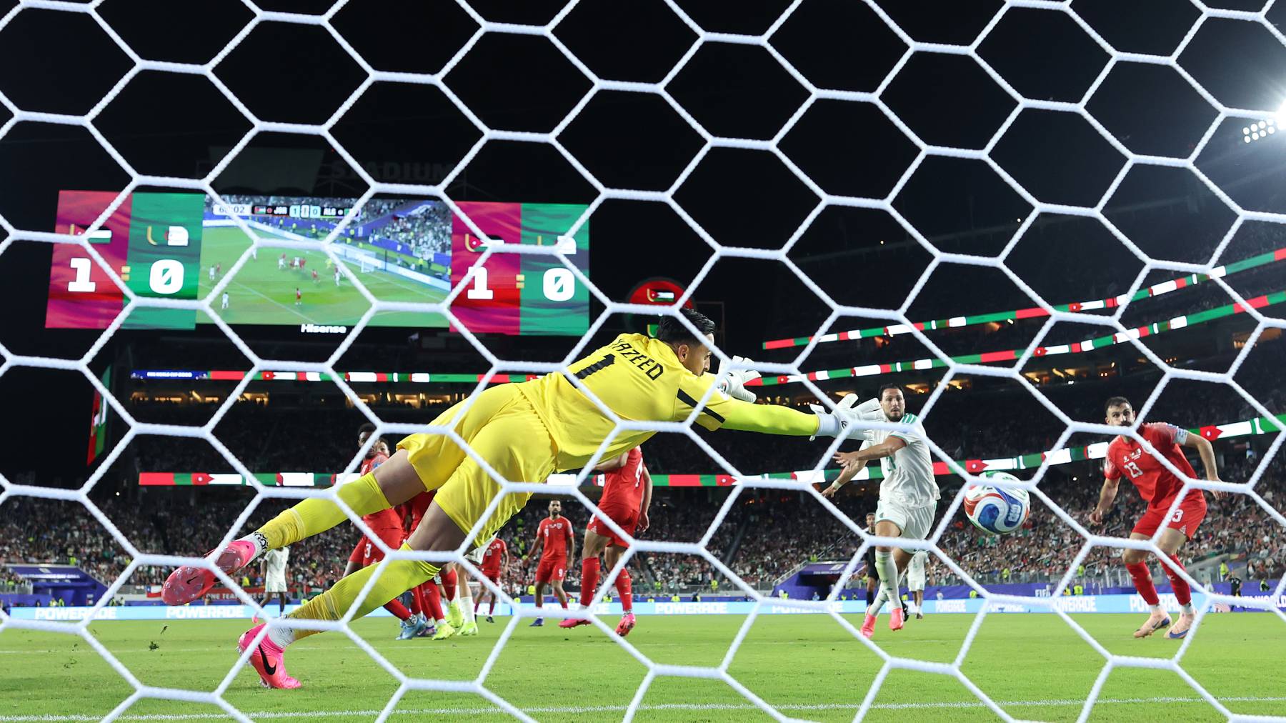 SANTA CLARA, CALIFORNIA - JUNE 22: (EDITOR'S NOTE: Image was captured using a remote camera from behind the goal.) Nadhir Benbouali #12 of Algeria scores his team's first goal past Yazeed Abulaila #1 of Jordan during the FIFA World Cup 2026 Group J match between Jordan and Algeria at San Francisco Bay Area Stadium on June 22, 2026 in Santa Clara, California. (Photo by Stu Forster/Getty Images)