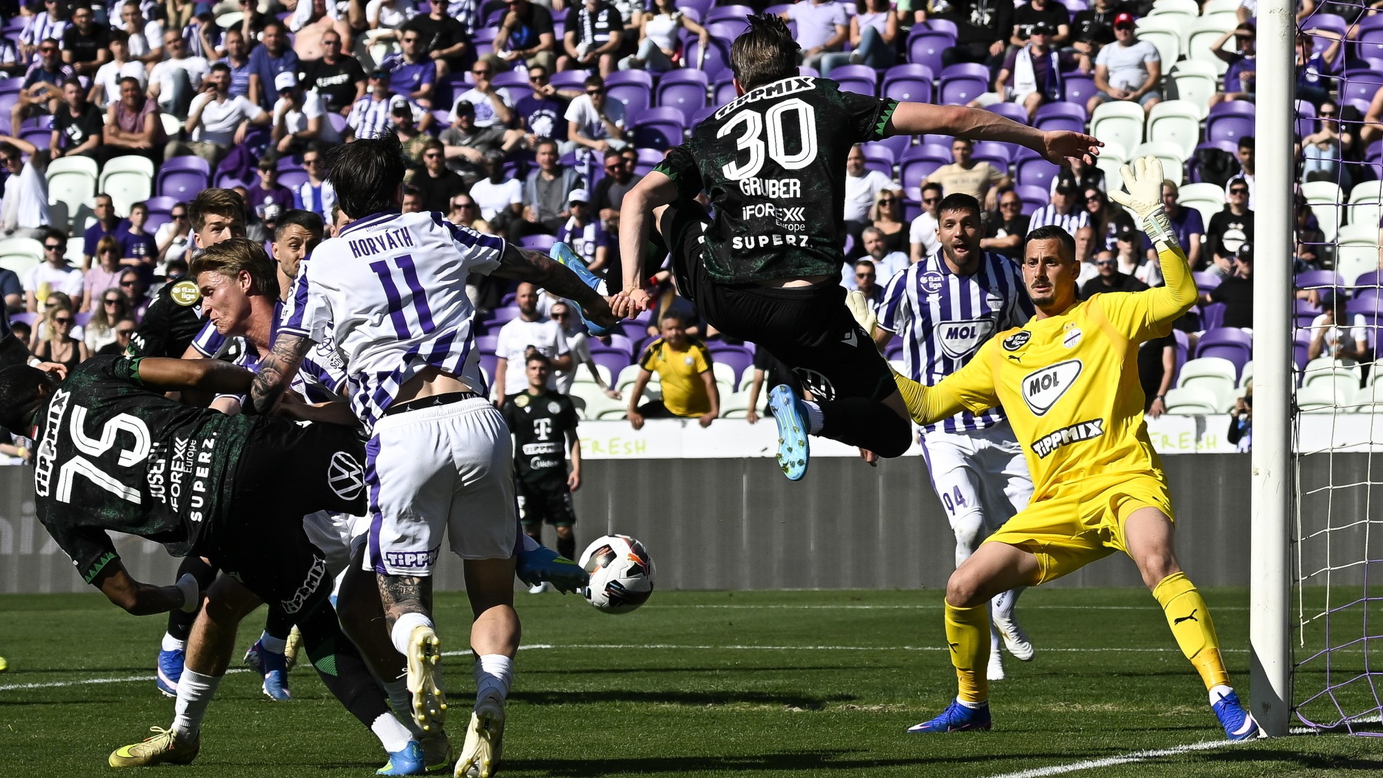 Banai Dávid, az Újpest kapusa (j), mögötte csapattársa, Patrizio Stronati (j2), középen Gruber Zsombor, a Ferencváros játékosa (j3) a labdarúgó Fizz Liga 32. fordulójában játszott Újpest FC - Ferencvárosi TC mérkőzésen a Szusza Ferenc Stadionban.
