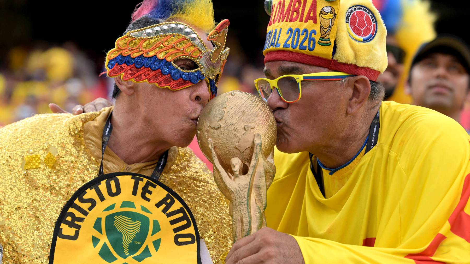 Colombian fans kiss a World Cup replica ahead of the 2026 World Cup round of 32 football match between Colombia and Ghana at the Kansas City Stadium in Kansas City on July 3, 2026.