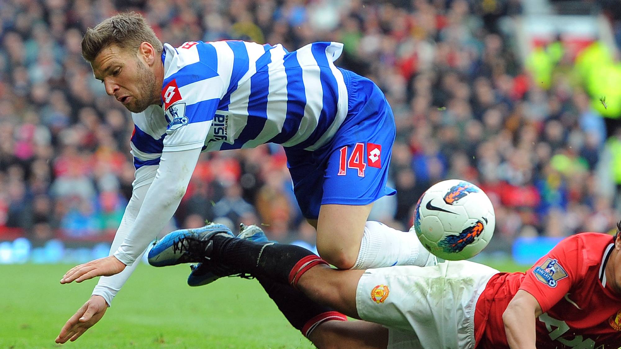 Queens Park Rangers Hungarian midfielder Ákos Buzsáky (L) vies with Manchester United's Brazilian defender Rafael Da Silva during the English Premier League football match between Manchester United and Queens Park Rangers at Old Trafford in Manchester, north-west England on April 8, 2012. AFP PHOTO/ANDREW YATES RESTRICTED TO EDITORIAL USE. No use with unauthorized audio, video, data, fixture lists, club/league logos or “live” services. Online in-match use limited to 45 images, no video emulation. No use in betting, games or single club/league/player publications.