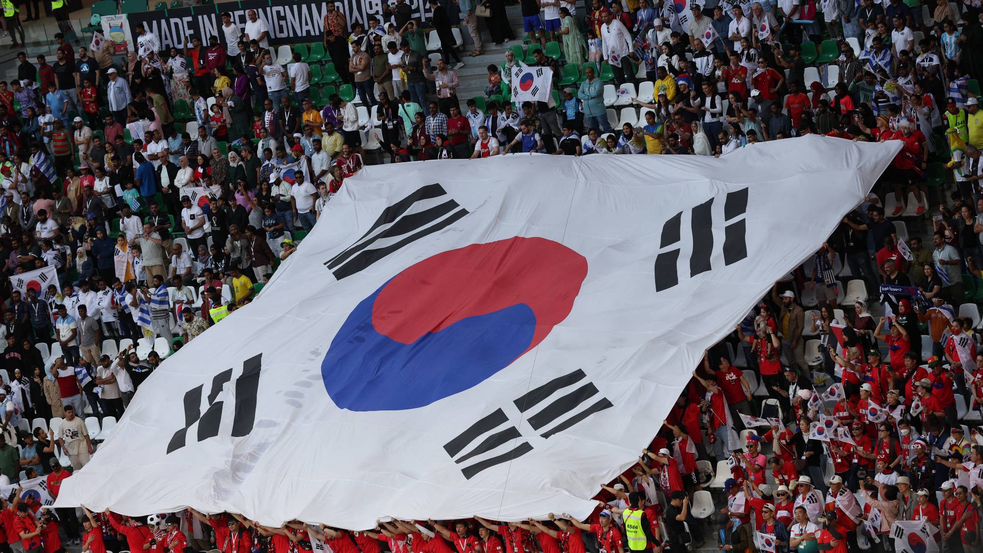 A large South Korean flag is displayed in the crown by supporters during the Qatar 2022 World Cup Group H football match between Uruguay and South Korea at the Education City Stadium in Al-Rayyan, west of Doha on November 24, 2022.