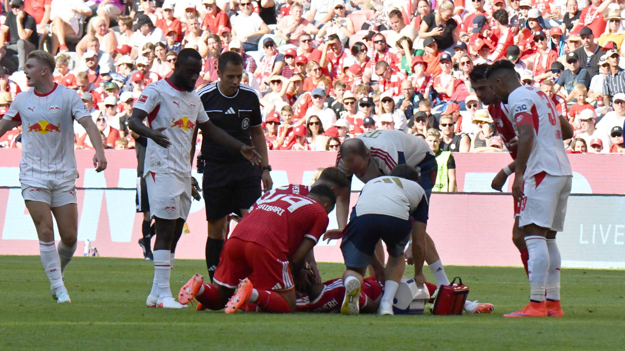 15.08.2026, Allianz Arena, Munich, Test match, FC FC Bayern Munich vs RB Leipzig , Jamal Musiala (Munich) collapses on the field, needs treatment, Ismael Saibari (Munich) holds his head. DFL regulations prohibit any use of photographs as image sequence