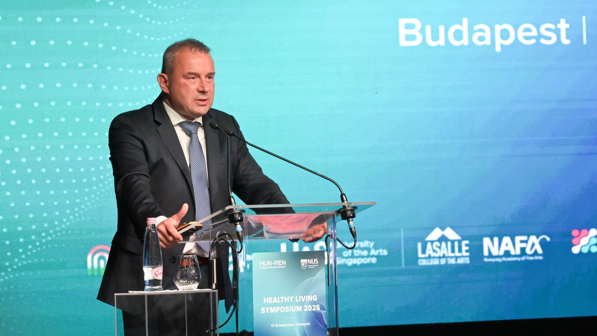 író Péter, a Nemzeti Sportügynökség elnök-vezérigazgatója beszédet mond a HUN-REN Magyar Kutatási Hálózat és a Szingapúri Nemzeti Egyetem (NUS) közös rendezvényének, a Healthy Living 2025 Symposium megnyitóján megnyitóján a Puskás Arénában 2025. szeptember 17-én.